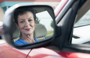 Older women looking in car mirror