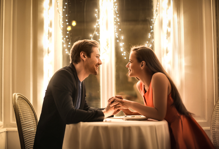 man and woman sitting at a table on a romantic date