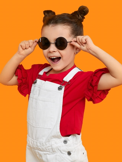 Child wearing white overalls and sunglasses