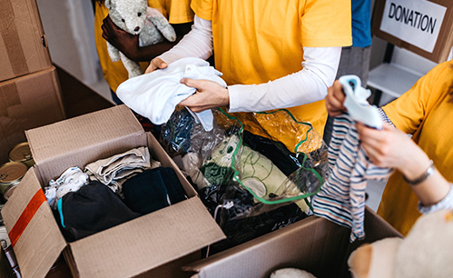 People folding clothes to put in a box