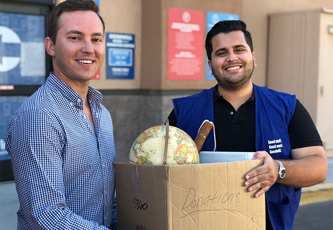 two men holding a donations box