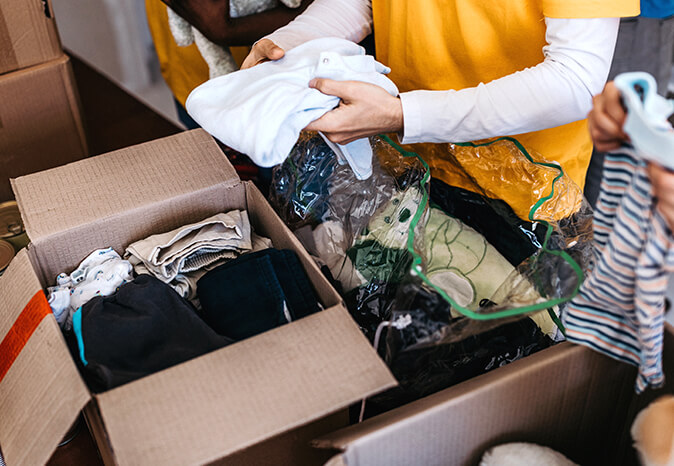 hands putting shirt in donation box