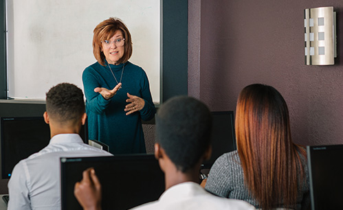 Women standing in front of a group of people teaching