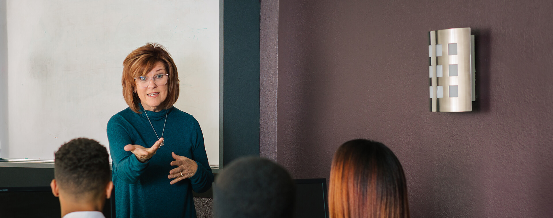 Women standing in front of a group of people teaching