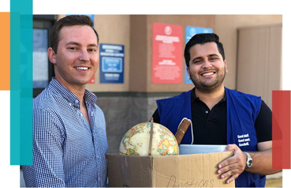 Two guys holding a box of donations