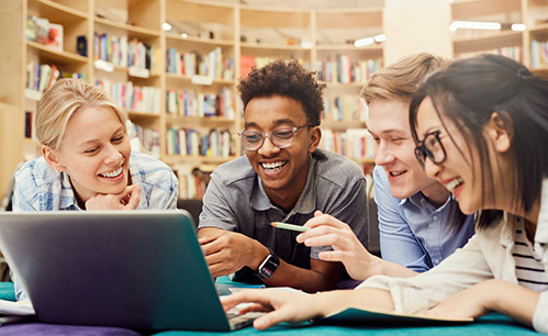 Group of people looking at a computer in the library