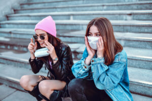 young girls in fashionable outfits sitting on bleachers