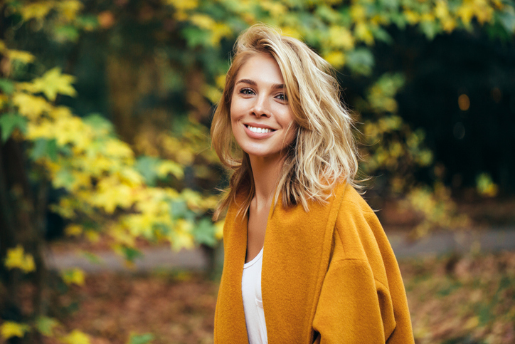 woman wearing coat and smiling at the camera