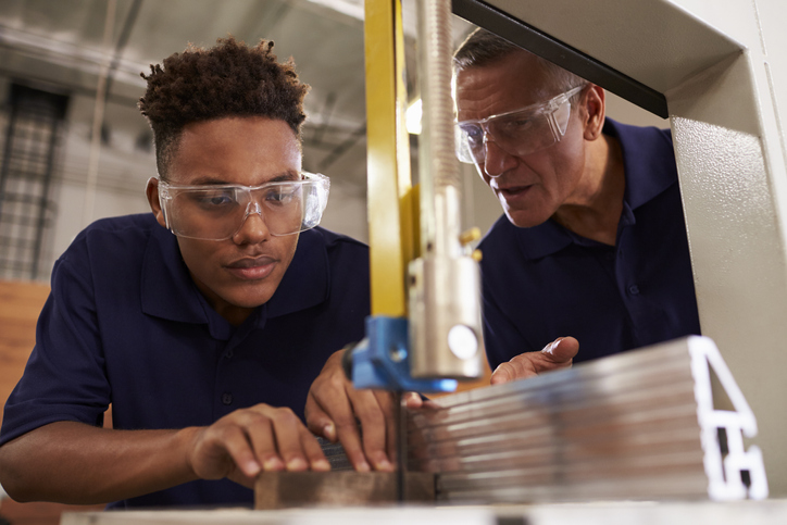 job training, Carpenter Training Male Apprentice To Use Mechanized Saw