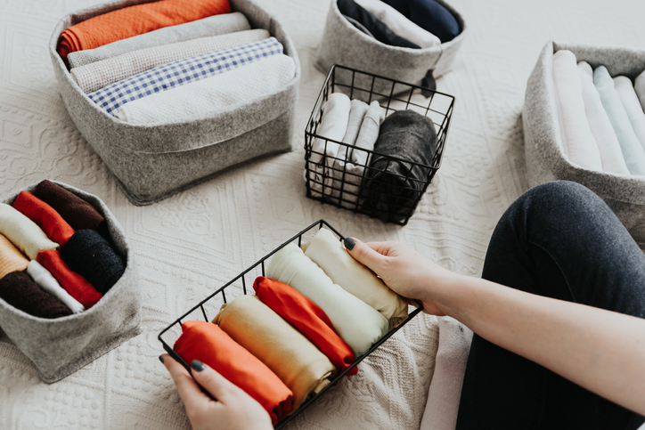 Wardrobe storage system. Clean up clothes with konmari method (Marie Kondo). Clothes neatly folded in bedroom