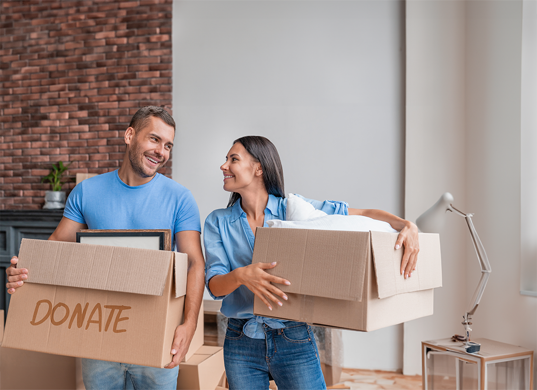 A smiling man and woman holding donation boxes