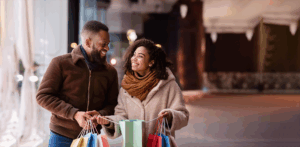 A man and a women walking outside holding shopping bags