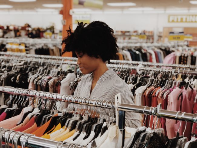 woman looking at clothing rack at a thrift shop