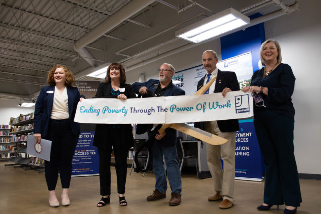 5 goodwill employees holding a banner